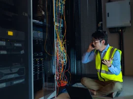 IT specialist coordinating an incident response beside network infrastructure