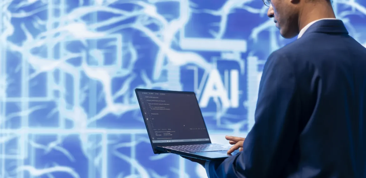 Cybersecurity analyst using a laptop in front of an artificial intelligence display